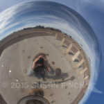 Reflected in the sphere of the sun dial at the VLA you can see the dishes of the Array off in the distance.